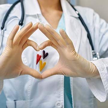 Doctor shows simbols of heart through the hands folded in the shape of a heart Doctor shows simbols of heart through the hands folded in the shape of a heart