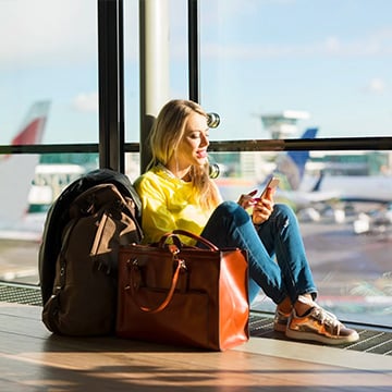 woman sitting in airport and working on phone woman sitting in airport and working on phone