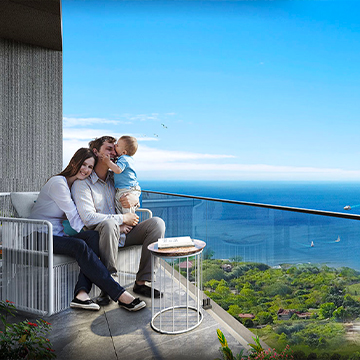 family sitting on balcony with sea view