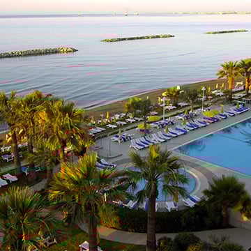 lots of sun beds around pool next to a beach lots of sun beds around pool next to a beach