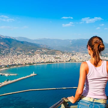 woman looking at city from a balcony woman looking at city from a balcony