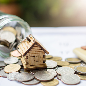 miniature house sitting on top of coins miniature house sitting on top of coins