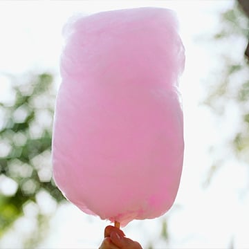 a hand holding a pink cotton candy a hand holding a pink cotton candy