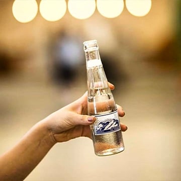 a hand holding a soft drink in bottle a hand holding a soft drink in bottle