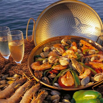 a dish in a metal plate with some champagne on some shrimps and seafood a dish in a metal plate with some champagne on some shrimps and seafood