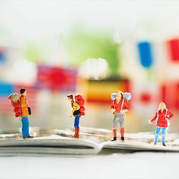 miniature figures on passports while blurred flags in background miniature figures on passports while blurred flags in background